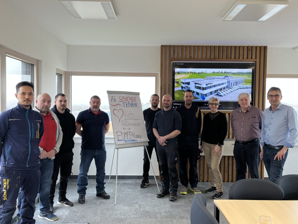 Gruppe vor Firmenpräsentation in Büro